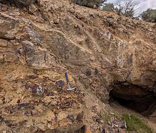Rock hammer against a mineralised outcrop at a historical working